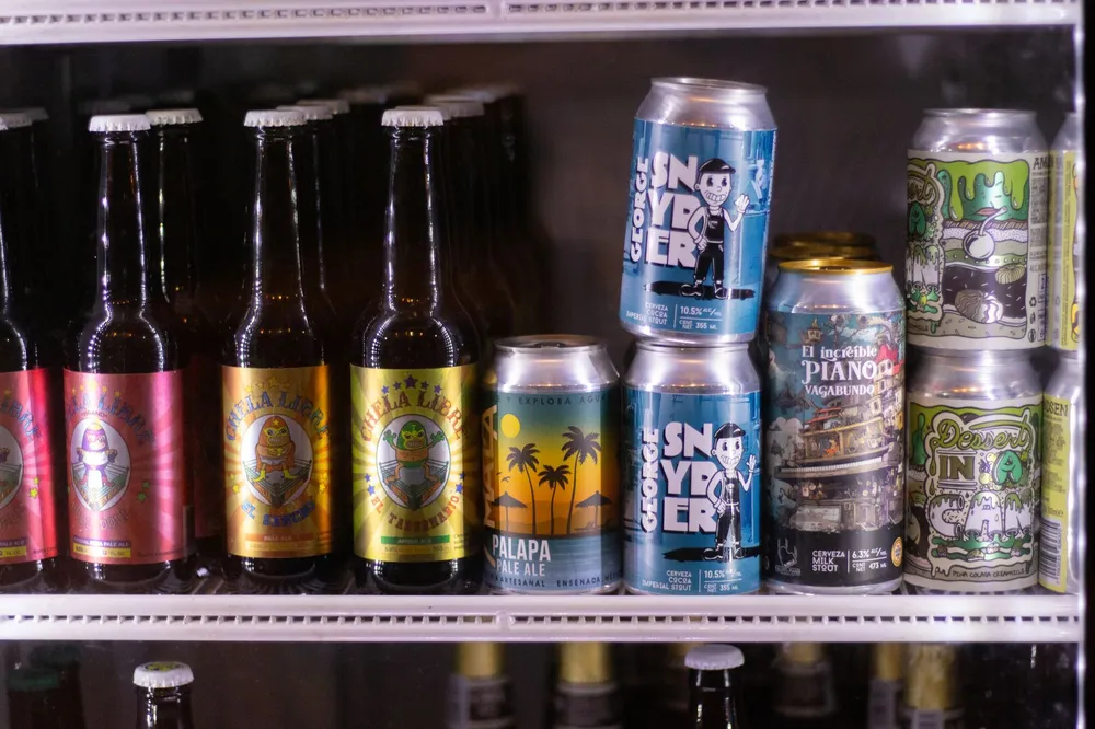 A row of craft beer cans and bottles lined up on a bar