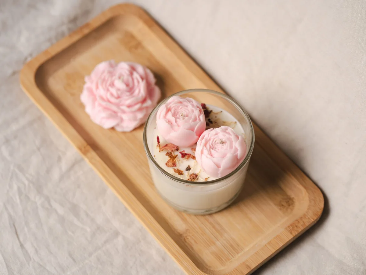 Floral candles in a glass on a wooden tray