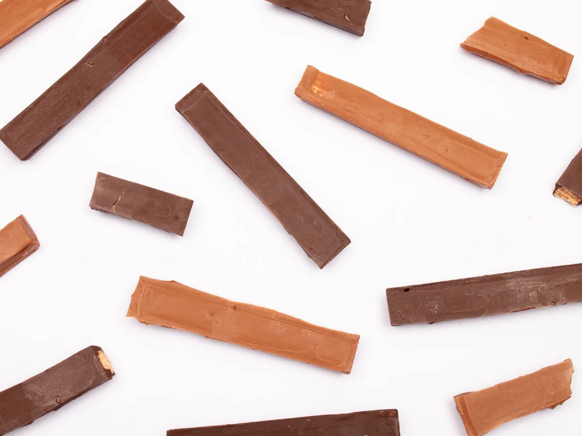 Bars of milk and dark chocolate scattered on a white table