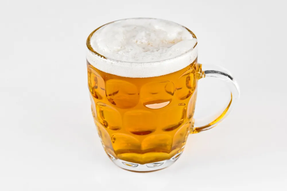 A pewter tankard of beer on a wooden pub table