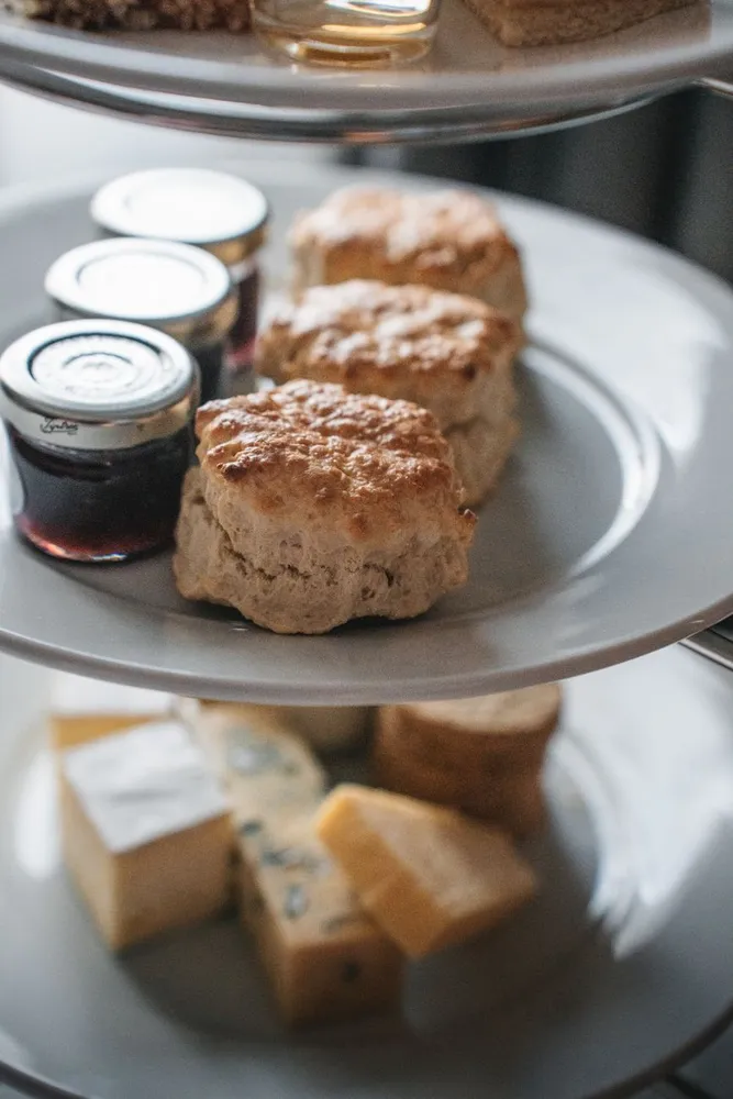 Scones split and topped with clotted cream and strawberry jam