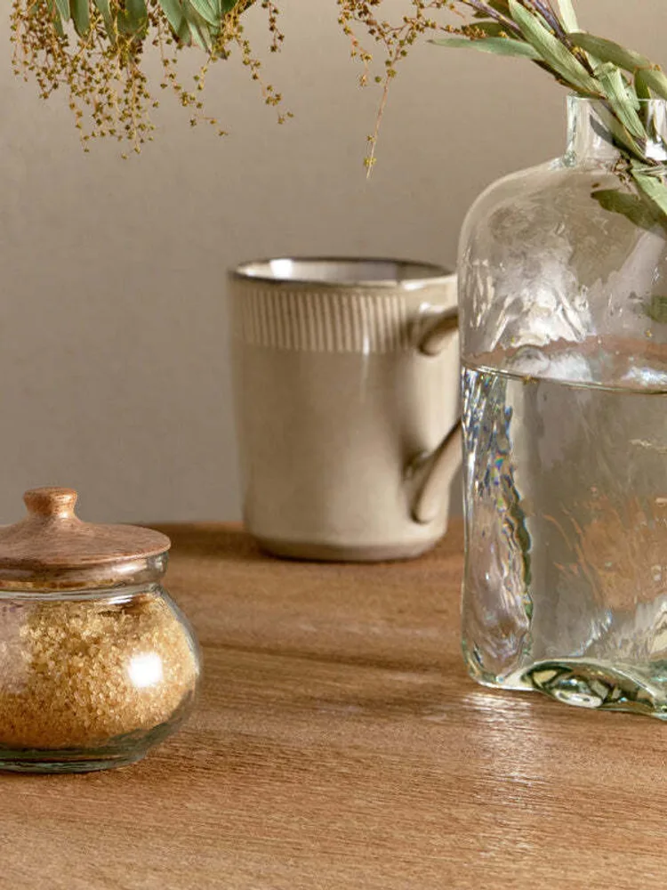 A round Nkuku Kali glass storage jar with wooden lid and spoon